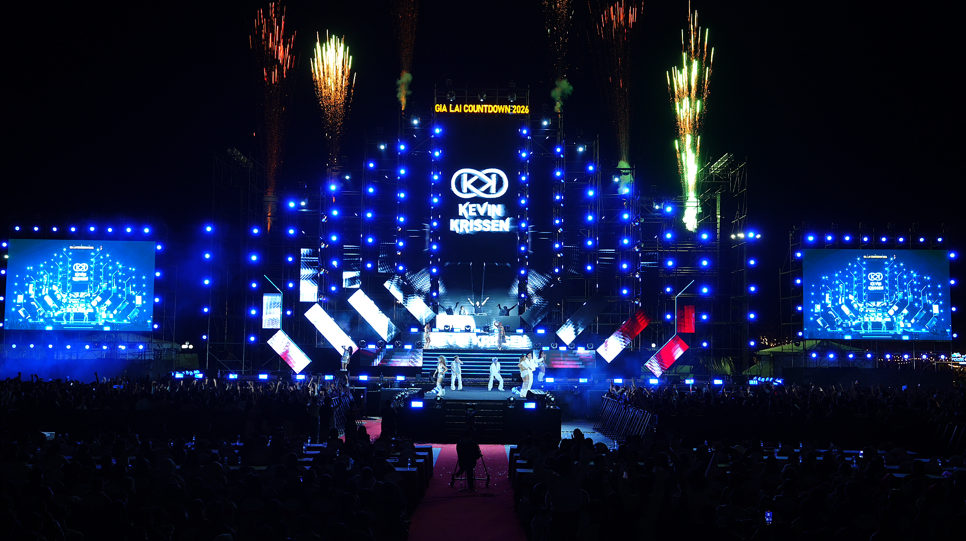 Kevin Krissen performing on a festival stage under fireworks